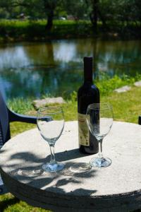a bottle of wine and two wine glasses on a table at Apartments Manitovac M in Nikšić