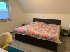 ein Schlafzimmer mit einem Bett mit einer bunten Decke darauf in der Unterkunft Ferienwohnung Henry in Waltrop