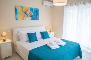 um quarto com uma cama azul e branca com toalhas em Helios: Charming beach home next to crystal waters em Nea Makri