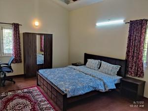 1 dormitorio con 1 cama con edredón azul en The Orchid Gardens, en Kodaikanal