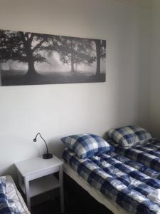 two beds in a room with a table and a picture on the wall at Kullan in Rättvik