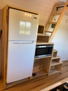 a refrigerator in a tiny kitchen with stairs at The Arkansas Tiny House in Mulberry