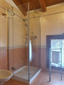 a glass shower in a bathroom with a sink at GARDAINN La CASCINA in Riva del Garda +15 photos