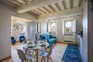 Luxury Suite in Florence - hosted by Sweetstay في فلورنسا: غرفة معيشة مع طاولة وأريكة زرقاء