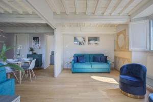 Luxury Suite in Florence - hosted by Sweetstay في فلورنسا: غرفة معيشة مع أريكة زرقاء وطاولة