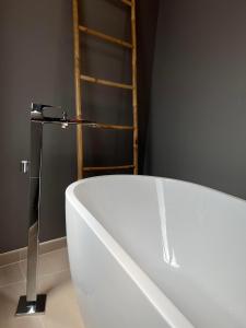 a white bath tub sitting in a bathroom at Hôtel Le Blason in Amboise