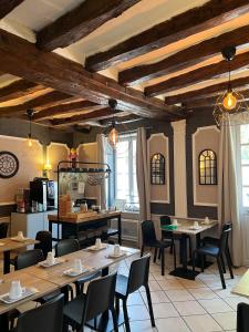 a restaurant with tables and chairs in a room at Hôtel Le Blason in Amboise