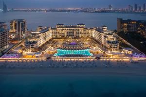 an aerial view of a hotel with a pool at night at Taj Exotica Resort & Spa, The Palm, Dubai in Dubai