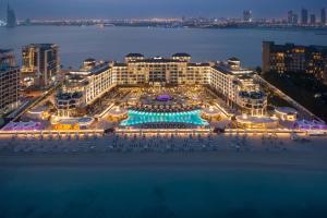 Taj Exotica Resort & Spa, The Palm, Dubai في دبي: اطلالة جوية على فندق مع مسبح بالليل