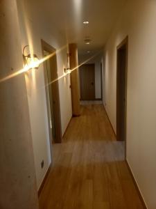 an empty hallway of an apartment with lights on the wall at Albergue La Huella in San Martín del Camino