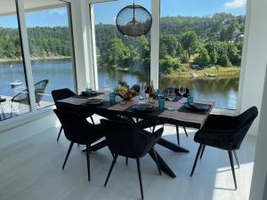 a dining room table with chairs and a view of a lake at Apartments Saaldorf-Ferienhaus mit 6 separaten Apartments 45qm-120qm in Bad Lobenstein