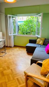 - un salon avec un canapé et une fenêtre dans l'établissement 70m2 apartment 4 mins from Athens central station!, à Athènes