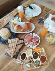 a table topped with plates of breakfast foods and orange juice at La Maison Grivolas Appartements et Maison d'hôtes in Avignon