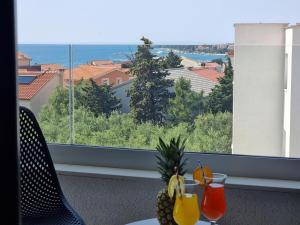 una mesa con dos vasos de zumo y vistas al océano en Villa SHARK Deluxe Novalja en Novalja