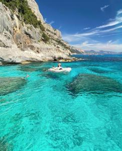 a couple of people in a boat in the water at Biriola EcoResort Cala Gonone in Cala Gonone