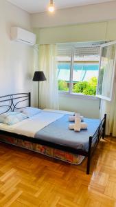 a bedroom with a bed with two towels on it at 70m2 apartment 4 mins from Athens central station! in Athens