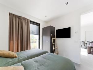 ゼーウォルデにあるSwanky villa in Zeewolde with gardenのベッドと薄型テレビのある寝室