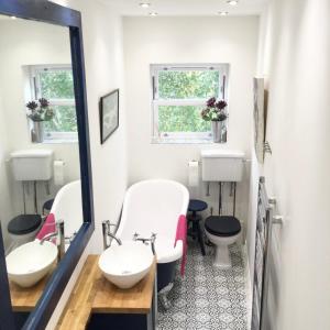 a bathroom with two sinks and a mirror at The ArtWorks in Hastings