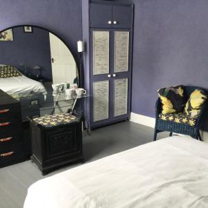 a bedroom with a bed and a vanity and a mirror at The ArtWorks in Hastings