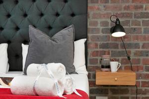 a bedroom with a bed with a pillow and a lamp at Urban Artisan Luxury Suites by Totalstay in Cape Town