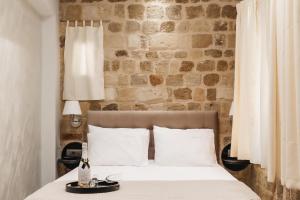 a bedroom with a bed and a brick wall at Chateau Anax Boutique Hotel in Rhodes Town