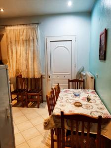 a dining room with a table and chairs and a refrigerator at Chéz Vasŏ ** leisure maisonette** in Kassandra