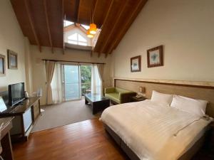 a bedroom with a bed and a desk and a television at Ailiga Travel Villa in Renai