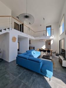 a living room with a blue couch and a table at Villa Célestine in Calvi