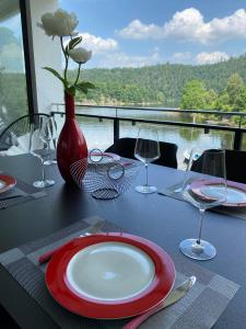 a table with a red and white plate and wine glasses at Apartments Saaldorf-Ferienhaus mit 6 separaten Apartments 45qm-120qm in Bad Lobenstein