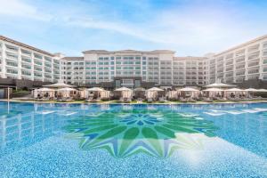 a large hotel with a large swimming pool with umbrellas at Taj Exotica Resort & Spa, The Palm, Dubai in Dubai