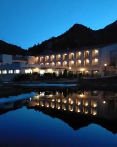 um edifício com luzes na água à noite em La Figuerola Hotel & Restaurant em Vandellós