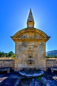a stone fountain with a face on top of it at Quinta do Quinto in Porto da Carne
