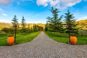 a brick road with two large orange vases on it at Quinta do Quinto in Porto da Carne