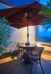 a table and chairs with an umbrella in front of a window at Verona Hotel and Conference Center in Ruiru