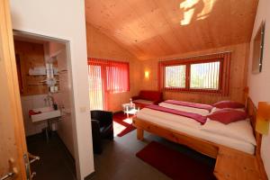 a bedroom with a bed and a sink in a room at Braugasthof Glocknerblick in Kals am Großglockner