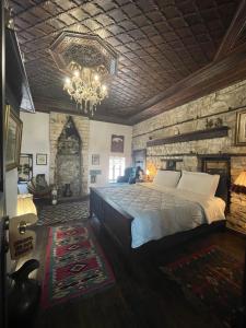 Un dormitorio con una cama grande y una lámpara de araña. en Hani i Xheblatit en Berat