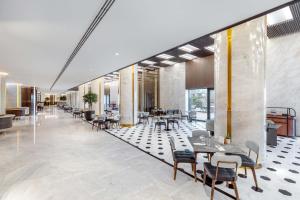 a lobby with tables and chairs in a building at Taj Exotica Resort & Spa, The Palm, Dubai in Dubai