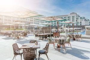 an outdoor patio with tables and chairs and umbrellas at Taj Exotica Resort & Spa, The Palm, Dubai in Dubai