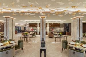 a restaurant with tables and chairs and a ceiling with butterflies at Taj Exotica Resort & Spa, The Palm, Dubai in Dubai