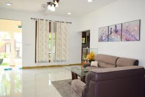 salon z kanapą i szklanym stołem w obiekcie Parallel villa w mieście Trikunamalaja
