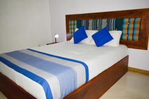 sypialnia z dużym łóżkiem z niebieskimi poduszkami w obiekcie Parallel villa w mieście Trikunamalaja