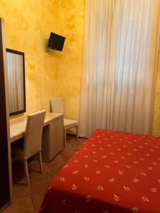 a hotel room with a desk and a bed and a mirror at B&B Del Corso in Margherita di Savoia