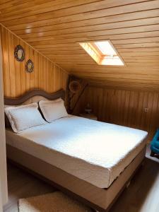 ウズンギョルにあるSelman Apart Hotelの木製の部屋にベッド1台が備わるベッドルーム1室があります。