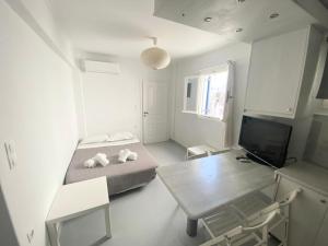 sypialnia z łóżkiem, stołem i telewizorem w obiekcie Ground floor Apartment in Mykonos Town w mieście Mykonos
