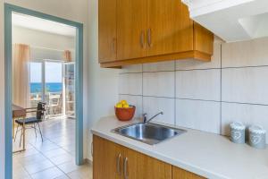 a kitchen with a sink and a view of the ocean at Seamoon apartment in Skopelos Town