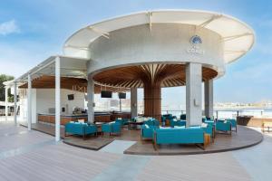 a restaurant with blue tables and chairs on a deck at Taj Exotica Resort & Spa, The Palm, Dubai in Dubai