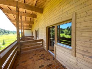 AngerbergにあるCozy Holiday Home in Angerberg with Saunaの大きな窓のある木造家屋の出口