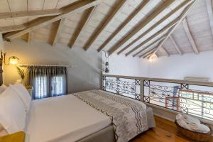 a bedroom with a white bed and a balcony at Irida Apartments in Stafylos