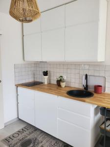 a kitchen with white cabinets and a sink at Charmant studio moderne avec extérieur "Dormir en provence" in Fontvieille
