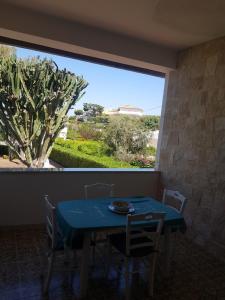 a table and chairs in a room with a large window at Il Paradiso Sul Mare in Syracuse